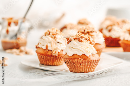 Muffin. Creme muffins with caramel and nuts. Creme on the top of muffin. Caramel muffins.  