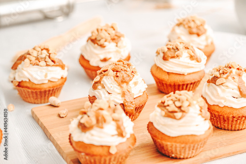 Muffin. Creme muffins with caramel and nuts. Creme on the top of muffin. Caramel muffins. 