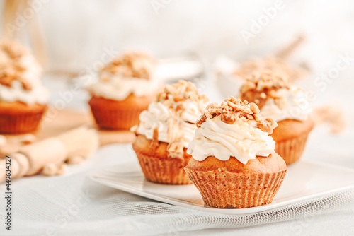 Muffin. Creme muffins with caramel and nuts. Creme on the top of muffin. Caramel muffins.  