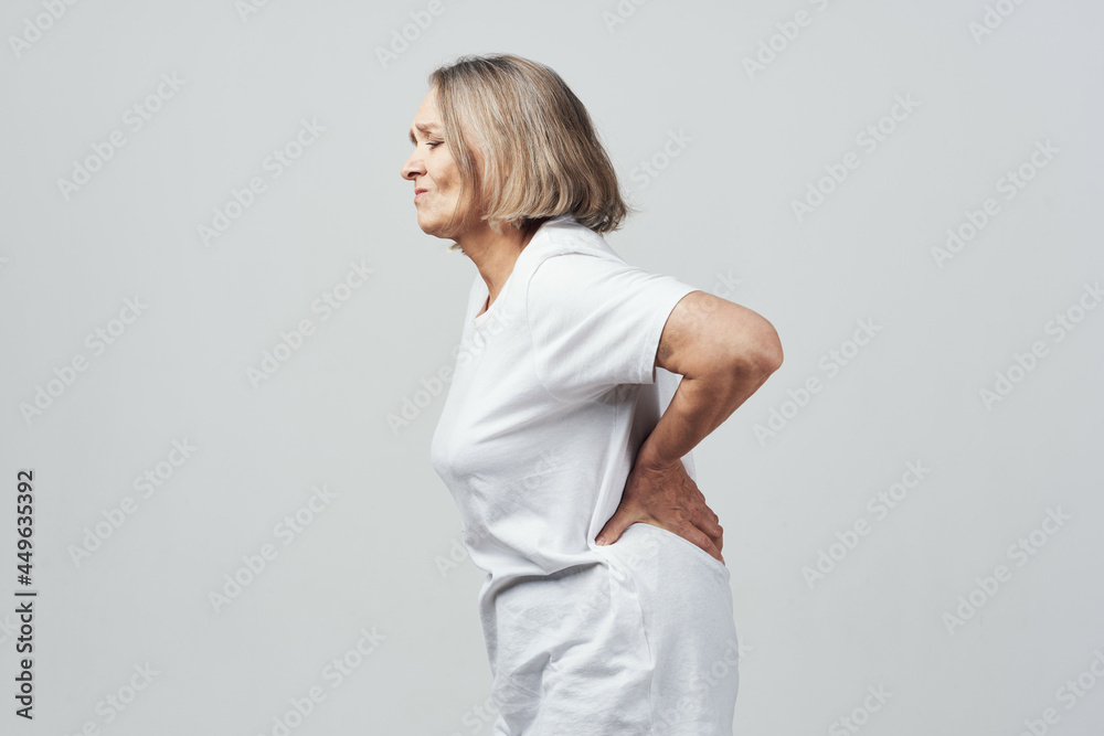 elderly woman holding her lower back back pain treatment elderly woman holding her lower back back pain treatment