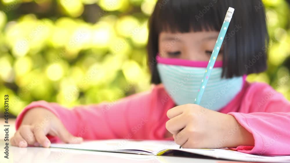 Selective focus chinese little girl write at class book Selective focus chinese little girl write at class book