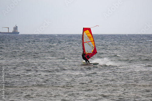 Orange and Red Windurf Riding the Waves in a Choppy Sea photo