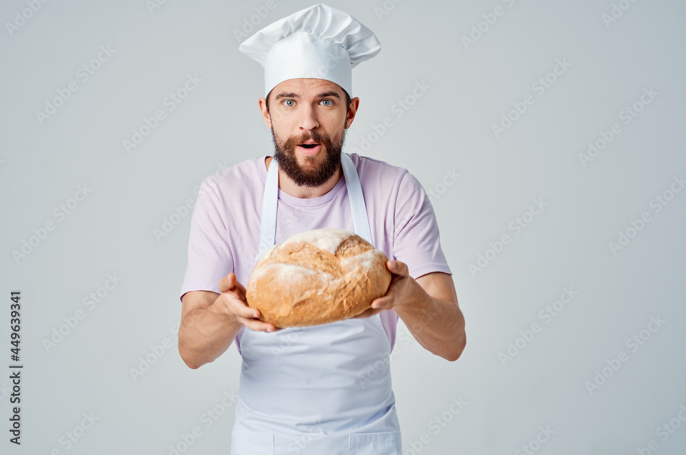 emotional Baker in a White apron with bread in his hands Professional emotional Baker in a White apron with bread in his hands Professional