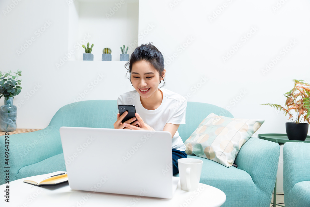 Young Asian woman holding notebook and smart phone while confirming work Young Asian woman holding notebook and smart phone while confirming work