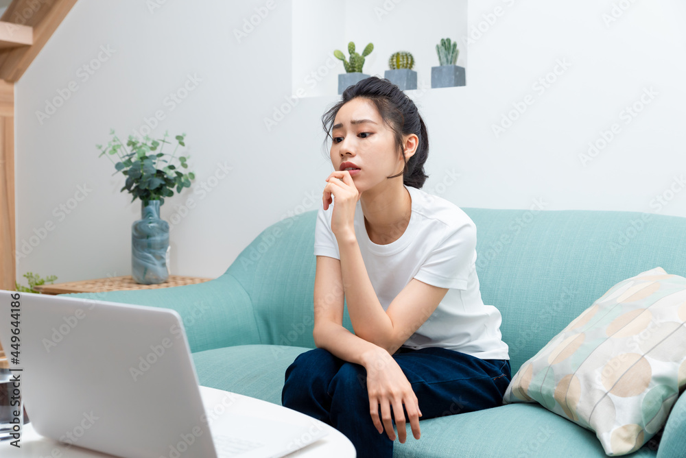 Asian young girl sitting and thinking at the computer Asian young girl sitting and thinking at the computer