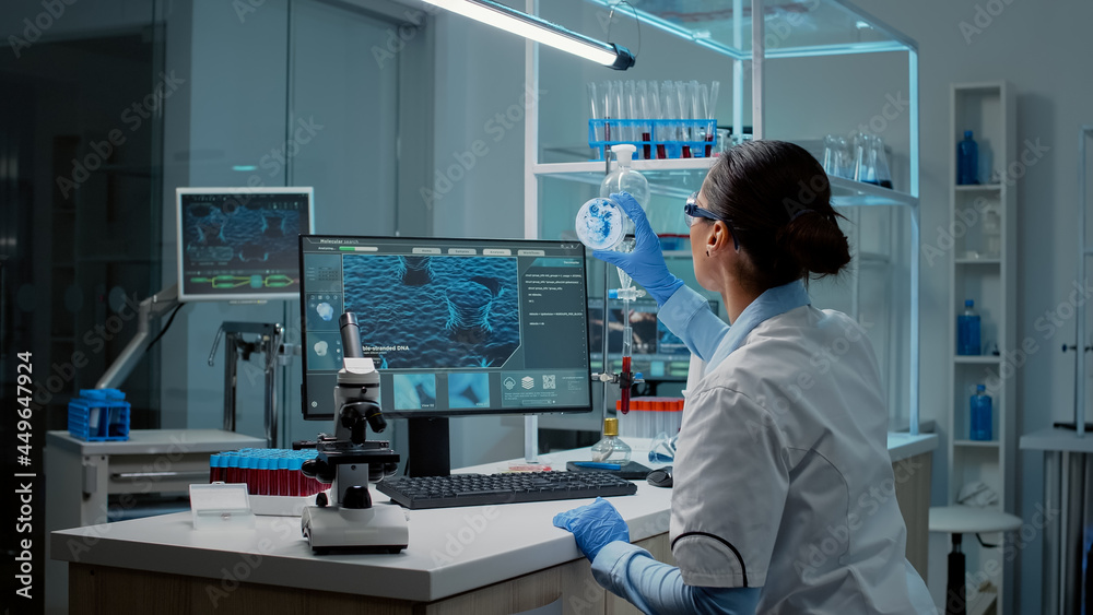 Biochemistry specialist doing research in laboratory with microscope ...