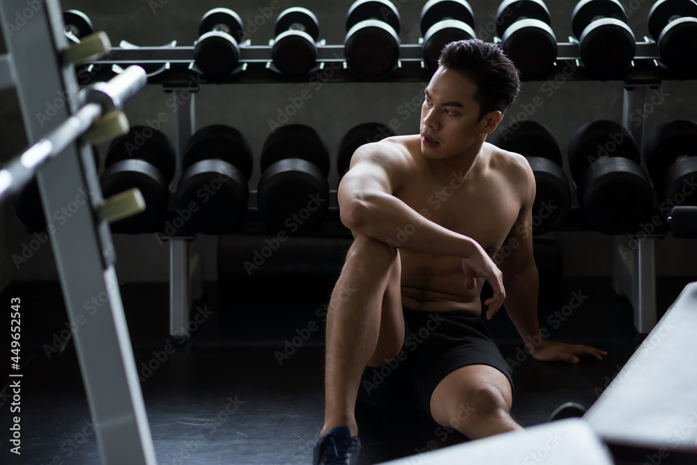 Muscle man rest after dumbbell practice in gym Muscle man rest after dumbbell practice in gym