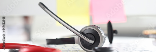 Stethoscope with headphones and microphone lie on computer keyboard