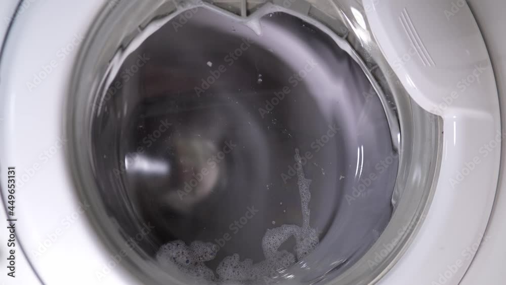 White washing machine washes dirty shoes. Washing shoes in domestic