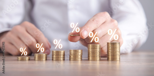 Man stacking coins with a percent symbols. photo