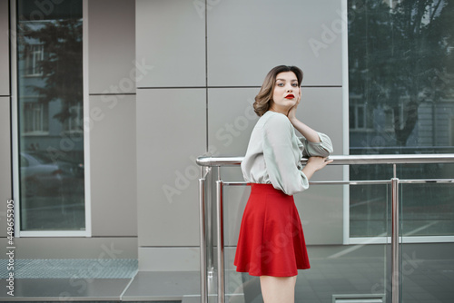 cheerful blonde near the building posing fashion red skirt