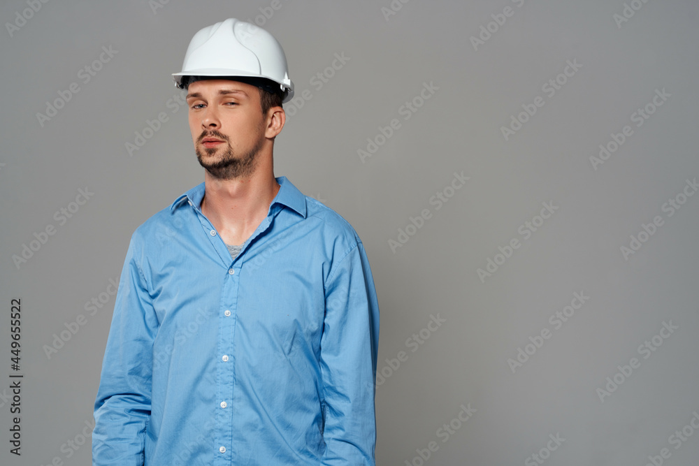 Cheerful male engineer in white construction helmet professional working