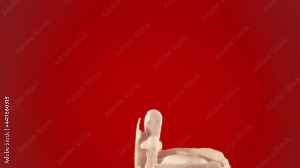 Reverse timelapse shot: a white chocolate ice cream bar coming back to its original shape from a messy state. Over a red backdrop.
Reverse timelapse shot: a white chocolate ice cream bar coming back to its original shape from a messy state. Over a red backdrop.