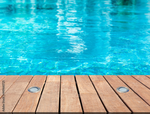 Piscine bleue avec plage bois et spots d’éclairage intégrés