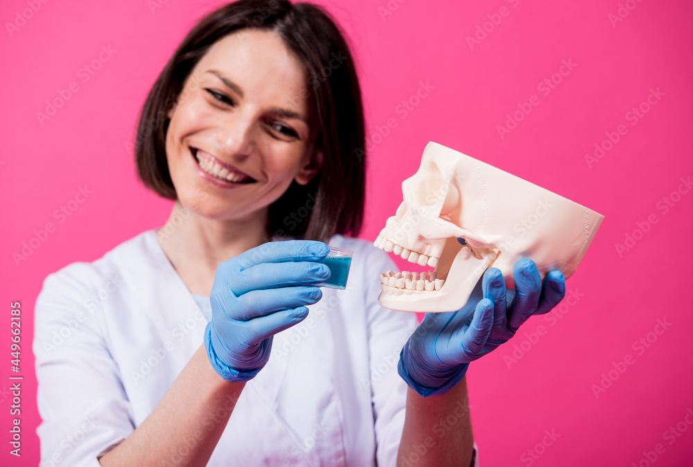 Beautiful girl proposes mouthwash for artificial skull Beautiful girl proposes mouthwash for artificial skull