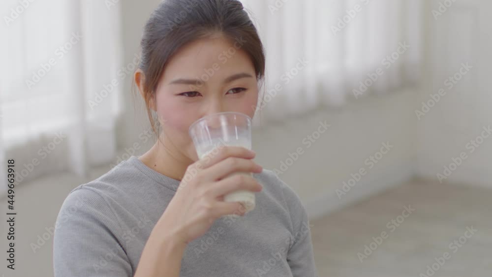 Healthy Young Asian woman Drinking milk with calcium for strong bone at home, Smiling woman holding soy milk on glass enjoy with nutrition wellness life, Wellness with natural milk fresh Concept Healthy Young Asian woman Drinking milk with calcium for strong bone at home, Smiling woman holding soy milk on glass enjoy with nutrition wellness life, Wellness with natural milk fresh Concept