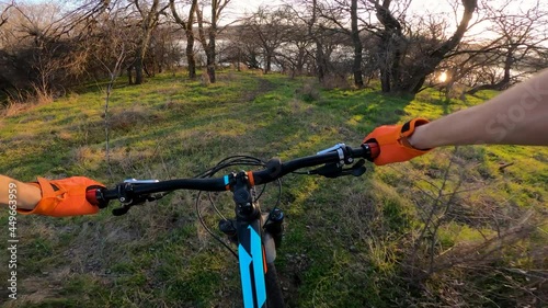 The cyclist goes down the forest path to the river. POV.