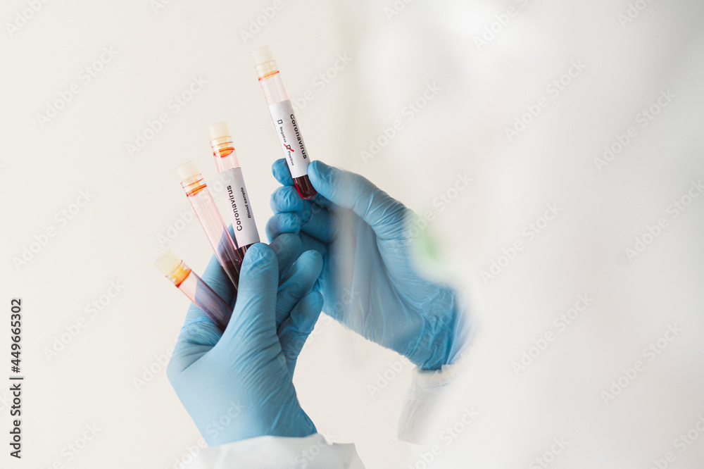 Selective focus of Corona virus blood sample in doctor hand in PPE suit. Selective focus of Corona virus blood sample in doctor hand in PPE suit.