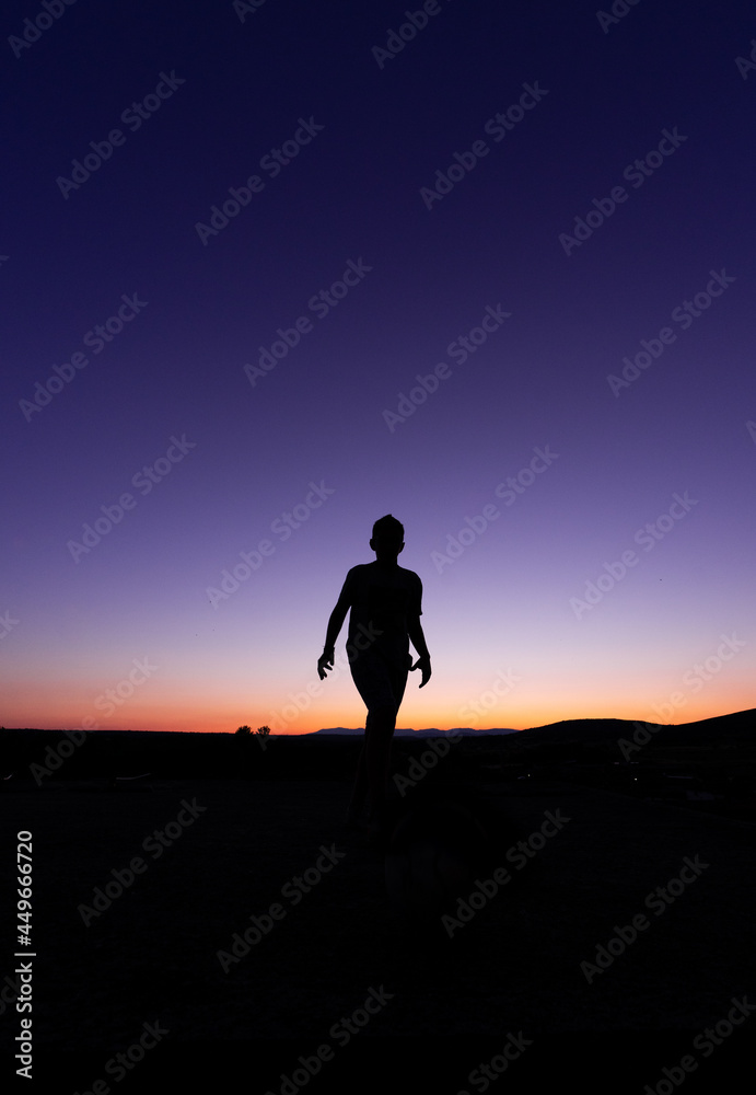 SILHOUETTE OF A CHILD APPROACHING DURING SUNSET SILHOUETTE OF A CHILD APPROACHING DURING SUNSET