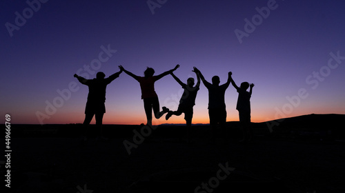 silhouette of a group of children jumping in the sunset