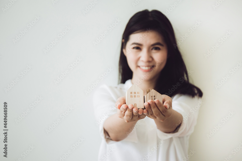 Selective focus of Wooden house and key on women hand. investment insurance and home purchase mortgage real estate concept. Selective focus of Wooden house and key on women hand. investment insurance and home purchase mortgage real estate concept.