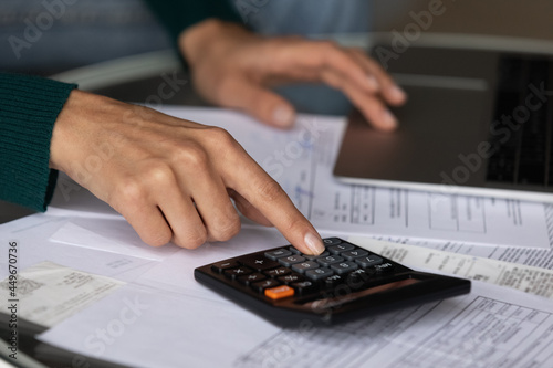 Close up woman using calculator and laptop, calculating domestic bills, finances, checking financial documents, analyzing receipts, client browsing online baking service, managing planning budget © fizkes