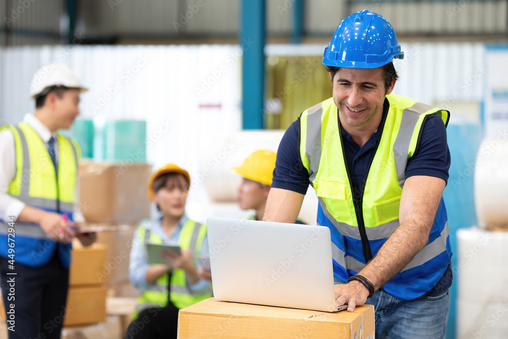 engineer or factory worker using laptop computer and talking to someone engineer or factory worker using laptop computer and talking to someone