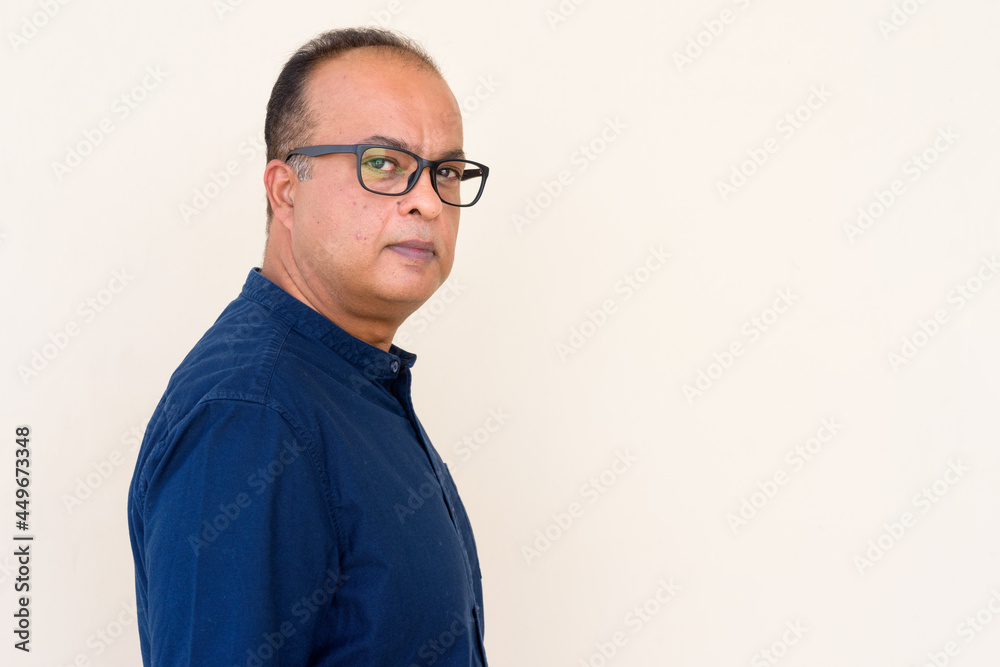 Portrait of Indian man against plain wall outdoors Portrait of Indian man against plain wall outdoors