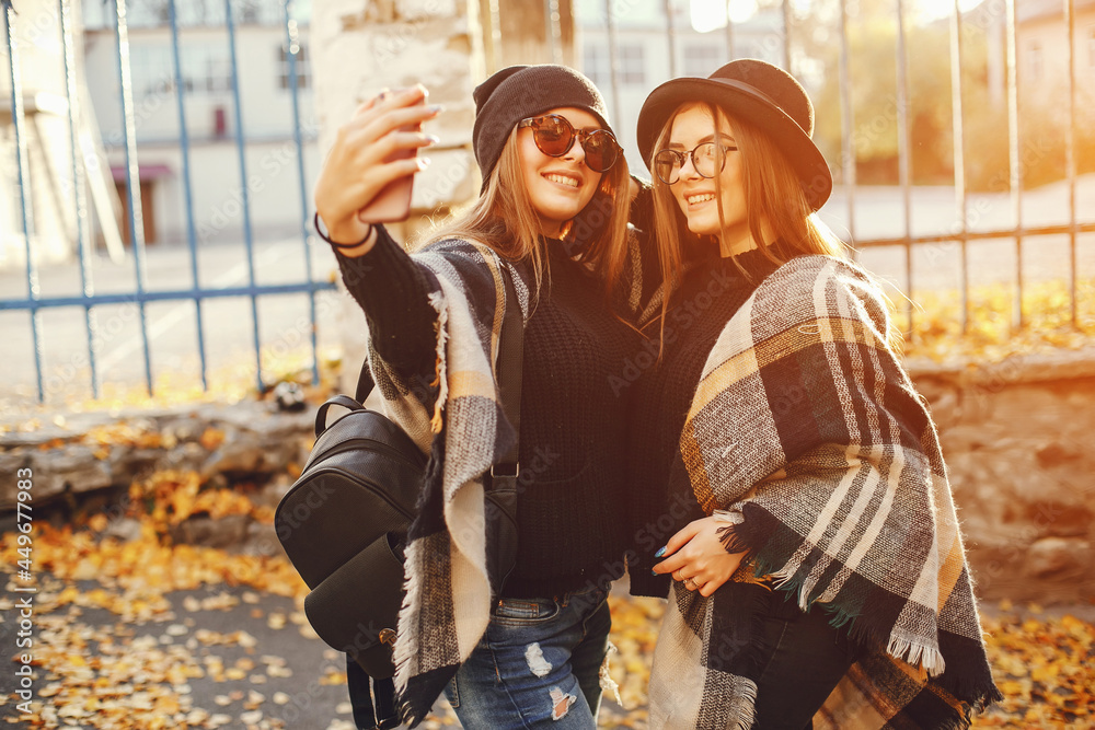 two young girls walk around the city in the autumn city and park two young girls walk around the city in the autumn city and park