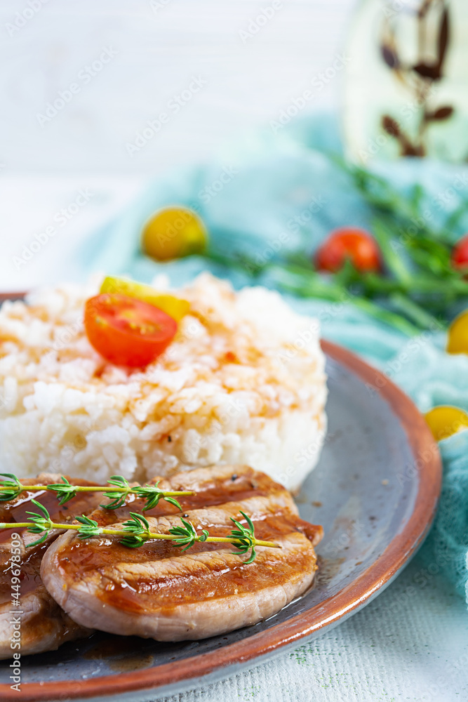 Rice with grilled pork meat, tomatoes and green herbs on white background Rice with grilled pork meat, tomatoes and green herbs on white background