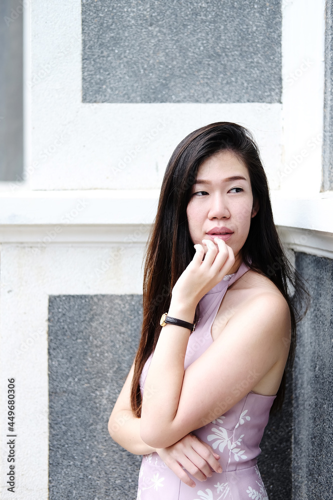 Young Asian beautiful woman is wearing dress pink and smiling and posting for street fashion at the city Young Asian beautiful woman is wearing dress pink and smiling and posting for street fashion at the city