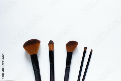 Brushes a flat lay with copy space. Beauty cosmetic makeup product layout. Stylish design. Creative fashionable concept. Cosmetics make-up brushes collection on a white background, top view. 