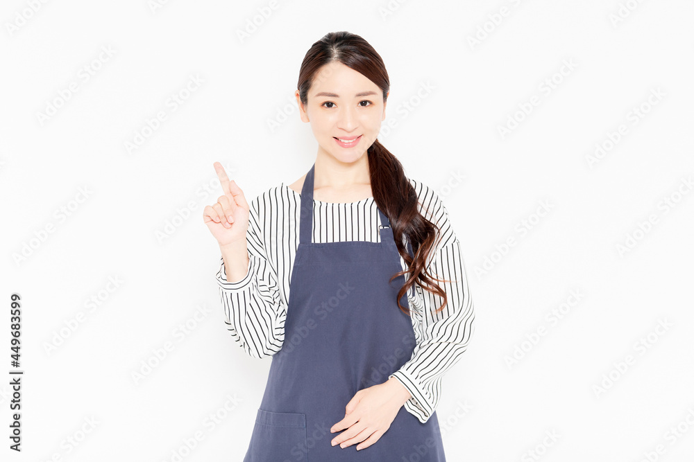 ポイントを示すエプロン姿の女性 ポイントを示すエプロン姿の女性