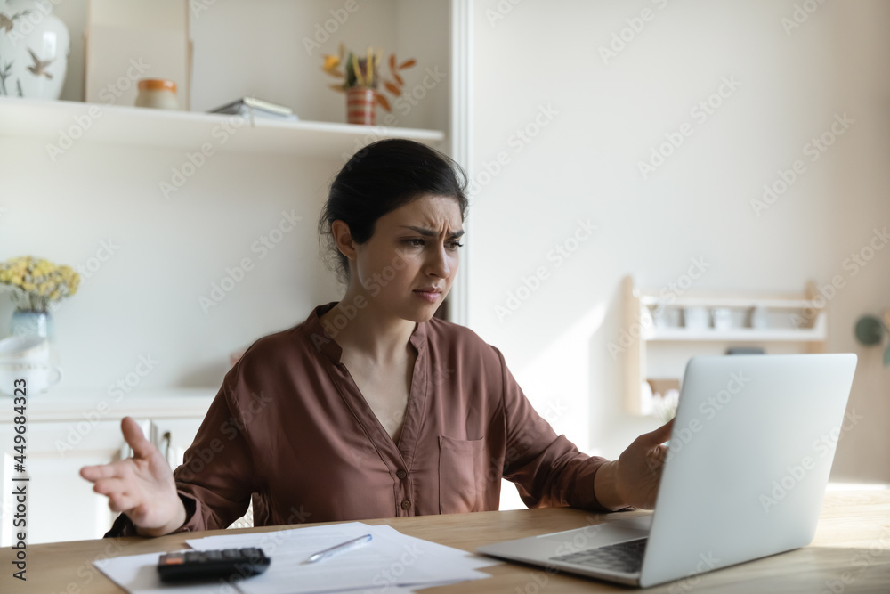 Unhappy Indian female use computer pay bills taxes online have error or mistake with internet banking. Upset ethnic woman distressed with debt or bankruptcy notice managing finances at home. Unhappy Indian female use computer pay bills taxes online have error or mistake with internet banking. Upset ethnic woman distressed with debt or bankruptcy notice managing finances at home.