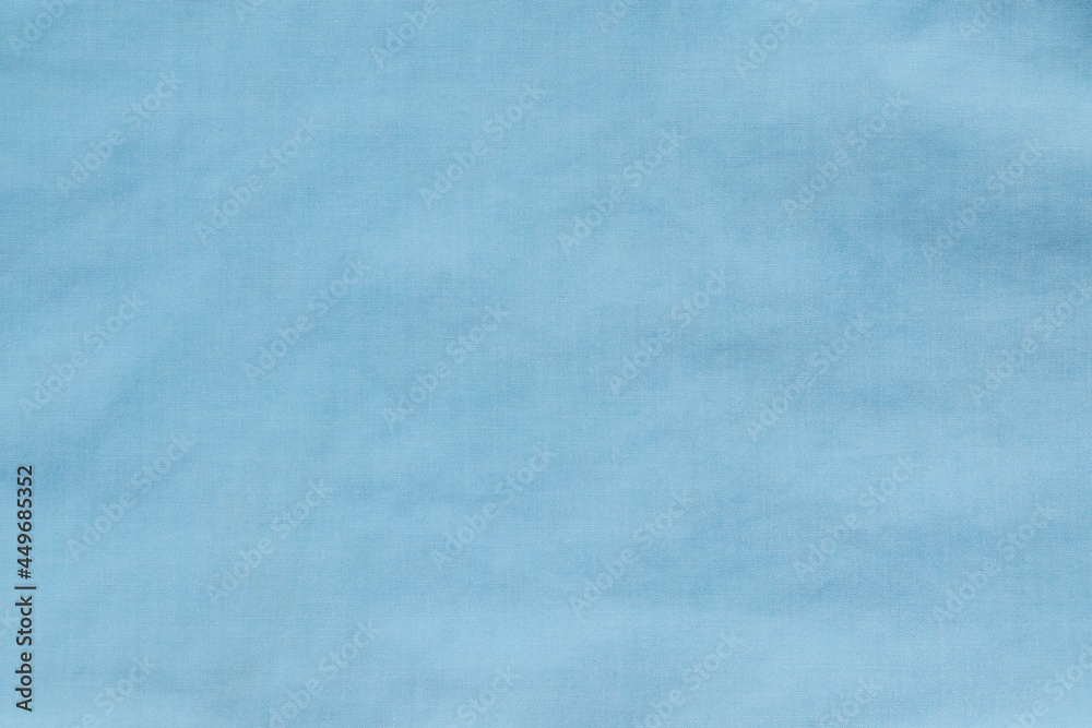 The texture of uneven natural cotton blue fabric, abstract background.