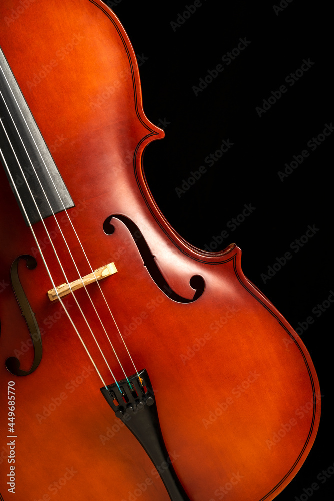 FRONT VIEW OF A TILTED CELLO ON DARK BACKGROUND. COPY SPACE. CLASSICAL MUSIC ORCHESTRA CONCERT. FRONT VIEW OF A TILTED CELLO ON DARK BACKGROUND. COPY SPACE. CLASSICAL MUSIC ORCHESTRA CONCERT.
