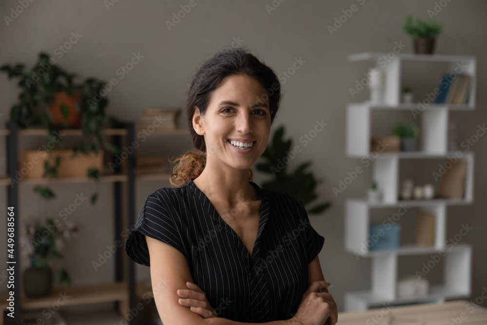 Head shot portrait of smiling woman standing with arms crossed at home, attractive successful confident businesswoman looking at camera, student freelancer posing for photo, profile picture Head shot portrait of smiling woman standing with arms crossed at home, attractive successful confident businesswoman looking at camera, student freelancer posing for photo, profile picture