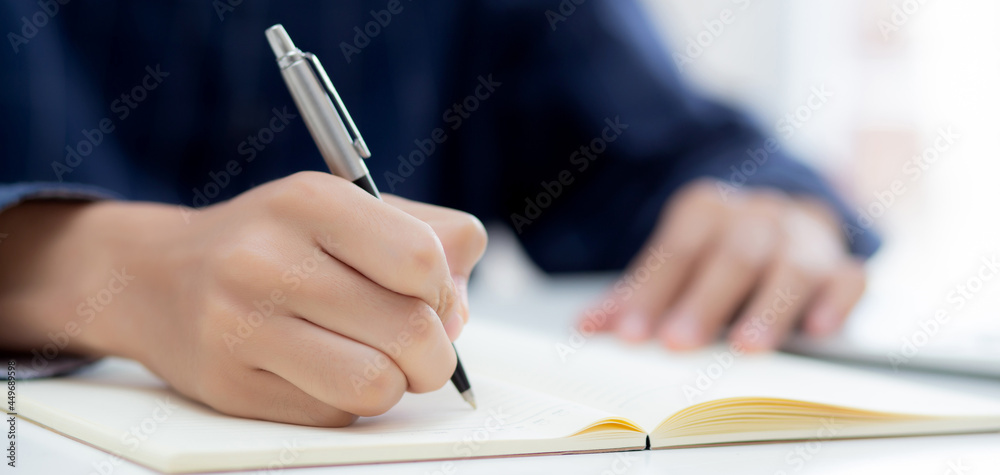 Closeup hand of man writing on notebook with pen on desk, freelance is author, businessman write on notepad on table, book, letter and report, finance and document, business or education concept. Closeup hand of man writing on notebook with pen on desk, freelance is author, businessman write on notepad on table, book, letter and report, finance and document, business or education concept.