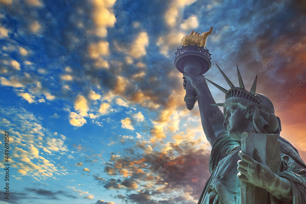 Fototapeta premium Dramatic view of the Statue of Liberty, with Manhattan in a red sunset background