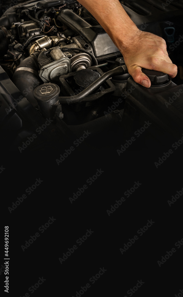 Auto mechanic working on car engine in mechanics garage. Repair service. Close-up shot. Free space for text, copy space