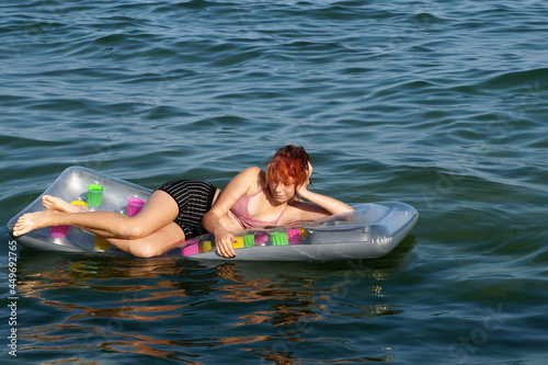 teenage girl lying on an inflatable mattress in the water © Anna