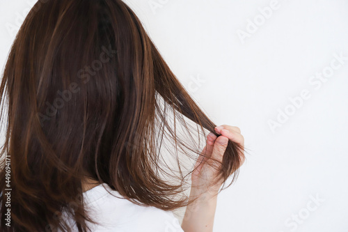 髪の毛を触る女性の後ろ姿