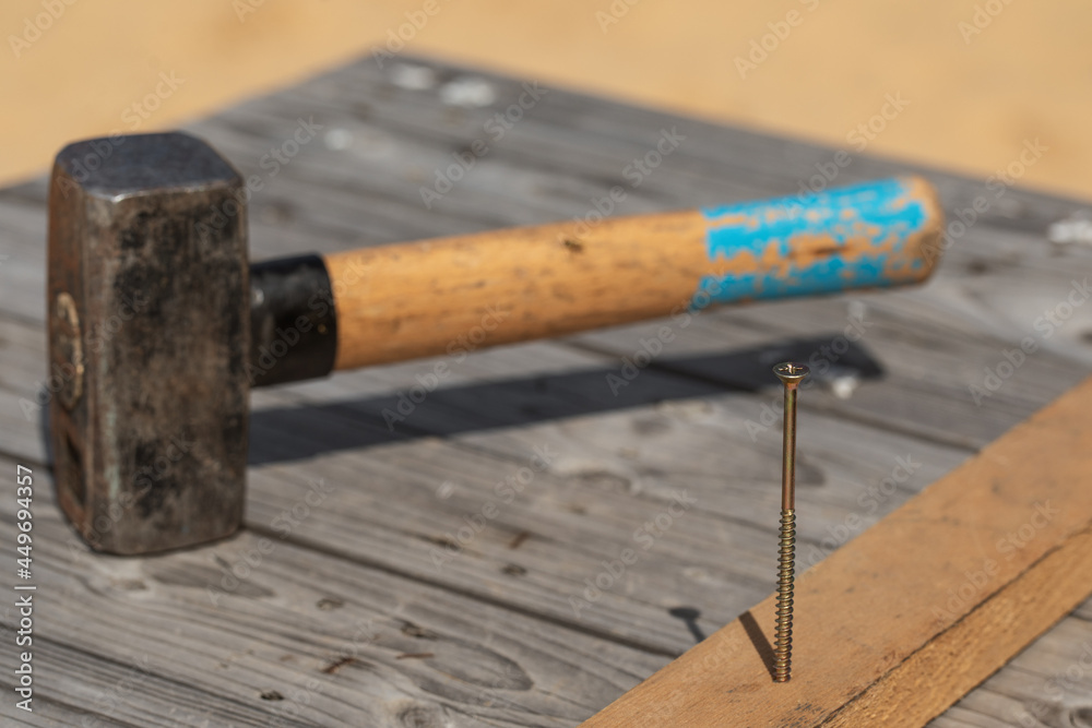 Hammer and nail on the old wood worktable