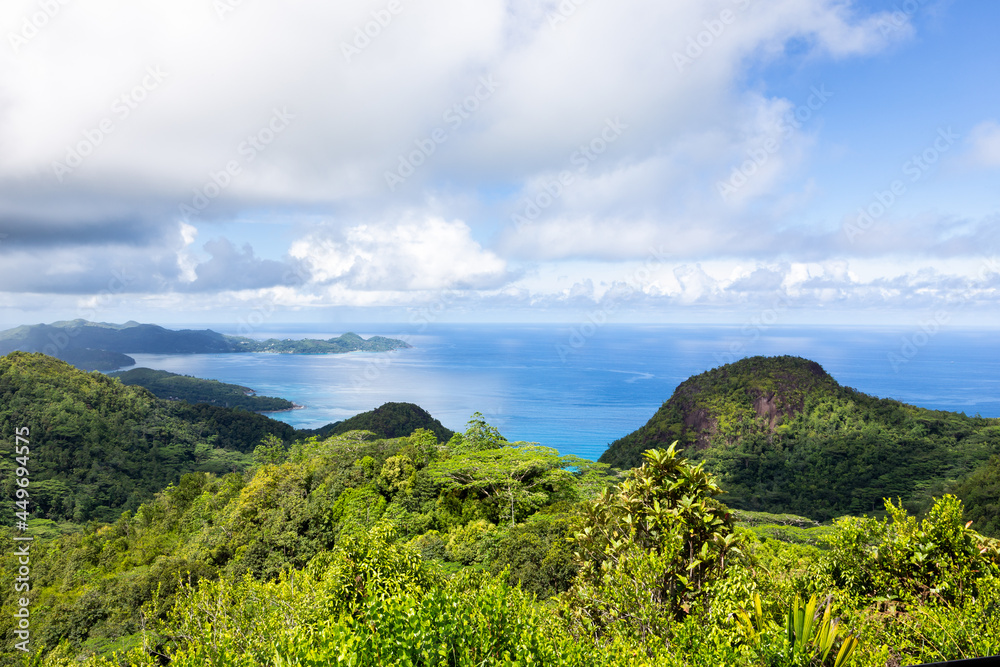 Landscape of Mahe Island coast seen from Venn's Town - Mission Lodge wooden viewing platform, lush tropical forest with crystal blue Indian Ocean.