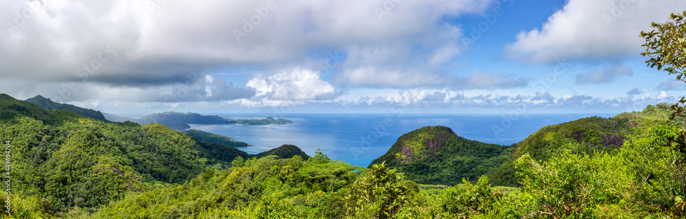Mahe Island coast panorama seen from Venn's Town - Mission Lodge wooden viewing platform, lush tropical forest with crystal blue Indian Ocean.