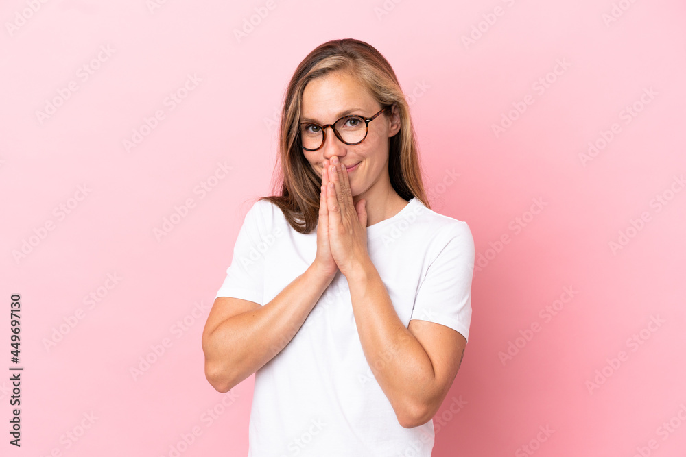 Young English woman isolated on pink background keeps palm together. Person asks for something Young English woman isolated on pink background keeps palm together. Person asks for something