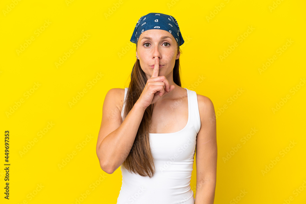 Young English woman isolated on yellow background showing a sign of silence gesture putting finger in mouth Young English woman isolated on yellow background showing a sign of silence gesture putting finger in mouth