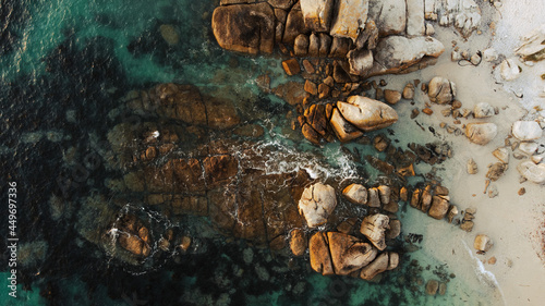Boulders in crystal clear water in Bakoven beach, Cape Town