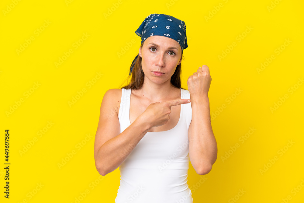 Young English woman isolated on yellow background making the gesture of being late Young English woman isolated on yellow background making the gesture of being late