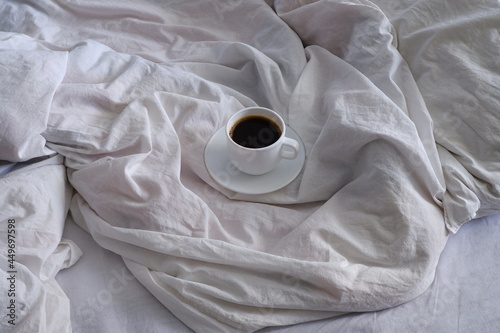 A cup of black coffee in bed. Interior. Cosiness.